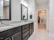 Bathroom featuring double sinks, granite countertops, dark wood cabinets, framed mirrors, and a view to the closet at 120 Bramble Ln, Clayton, NC 27527