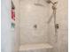 Neutral colored tiled shower with a built-in bench seat, showerhead, and storage niche at 120 Bramble Ln, Clayton, NC 27527