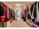 Spacious walk-in closet with carpeted floor and clothing racks on both sides leading to a door at 120 Bramble Ln, Clayton, NC 27527