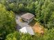 Aerial view of a home with a gravel driveway and wooded surroundings at 121 Pheasant Ct, Pittsboro, NC 27312