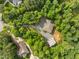 An aerial view of private home with barn, set amongst mature trees and a gravel driveway at 121 Pheasant Ct, Pittsboro, NC 27312