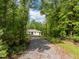 Secluded home exterior on a tree-lined lot featuring a long gravel driveway at 121 Pheasant Ct, Pittsboro, NC 27312