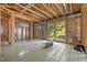 Unfinished living room with radiant floor heating, sliding glass doors, and exposed wood framing at 121 Pheasant Ct, Pittsboro, NC 27312