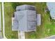 An aerial view of a gray-roofed house with a gray patio, surrounded by green grass and trees at 122 Swansboro Ln, Chapel Hill, NC 27516