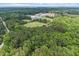 Wide aerial shot featuring neighborhood, sports field, large building and dense forest at 122 Swansboro Ln, Chapel Hill, NC 27516