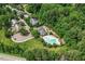 An aerial view of community amenities including a pool, playground, and picnic area surrounded by lush trees at 122 Swansboro Ln, Chapel Hill, NC 27516