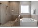 Spa-like bathroom featuring a glass shower and a soaking tub with tile surround at 122 Swansboro Ln, Chapel Hill, NC 27516