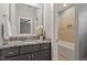 Bathroom featuring granite counters, a large mirror, and a tiled shower/tub at 122 Swansboro Ln, Chapel Hill, NC 27516