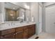 Modern bathroom featuring double sinks, white countertops, brown cabinets and a shower at 122 Swansboro Ln, Chapel Hill, NC 27516