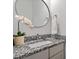 Bathroom featuring granite countertops, modern sink and stylish round mirror at 122 Swansboro Ln, Chapel Hill, NC 27516