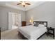 Neutral bedroom with ceiling fan and open door to bathroom with glass shower at 122 Swansboro Ln, Chapel Hill, NC 27516