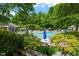 Lush community pool area with various sitting areas, umbrellas, and playground equipment at 122 Swansboro Ln, Chapel Hill, NC 27516