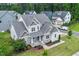 Aerial view of a two-story home with detailed roof, manicured lawn and beautiful landscaping at 122 Swansboro Ln, Chapel Hill, NC 27516