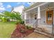 Inviting front porch with stone columns, railing, and beautifully landscaped garden at 122 Swansboro Ln, Chapel Hill, NC 27516