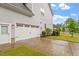 Side view of a two-car garage and an entrance door with clean concrete driveway and landscaping at 122 Swansboro Ln, Chapel Hill, NC 27516