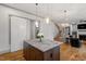 Kitchen island with pendant lights open to living area and staircase at 122 Swansboro Ln, Chapel Hill, NC 27516