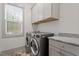 Laundry room with washer, dryer, counterspace, cabinets, and window at 122 Swansboro Ln, Chapel Hill, NC 27516