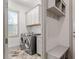 Convenient laundry room with washer, dryer, cabinets, bench and window at 122 Swansboro Ln, Chapel Hill, NC 27516