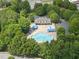Aerial view of community pool with blue umbrellas, surrounded by trees and a clubhouse at 12501 Garden Tree Ln, Raleigh, NC 27614