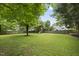 Spacious backyard with lush green grass, surrounded by a wooden fence and mature trees, perfect for outdoor activities at 12501 Garden Tree Ln, Raleigh, NC 27614