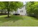 Exterior view of the house with deck, lush green lawn, and mature trees at 12501 Garden Tree Ln, Raleigh, NC 27614