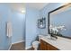 Light blue bathroom featuring a vanity, toilet, wall decor and a towel rack with white towels at 12501 Garden Tree Ln, Raleigh, NC 27614