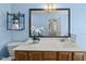 Well-lit blue bathroom featuring vanity with countertop, toilet, and decorative wall shelving at 12501 Garden Tree Ln, Raleigh, NC 27614