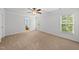 Bright bedroom with neutral carpet, ceiling fan, two windows, and a glimpse into an adjacent bathroom at 12501 Garden Tree Ln, Raleigh, NC 27614