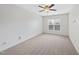 Bedroom featuring neutral carpet, a ceiling fan, a window with blinds, and plain walls at 12501 Garden Tree Ln, Raleigh, NC 27614