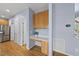 Bright hallway with built in desk area, hardwood floors, and access to stainless steel refrigerator at 12501 Garden Tree Ln, Raleigh, NC 27614