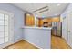 Well-lit kitchen with wooden cabinets, stainless steel refrigerator, and hardwood floors at 12501 Garden Tree Ln, Raleigh, NC 27614