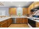 Well-lit kitchen featuring light wood cabinets, stainless steel appliances, and a tile backsplash at 12501 Garden Tree Ln, Raleigh, NC 27614