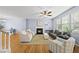 Spacious living room with fireplace, ceiling fan, and hardwood floors, filled with natural light from large windows at 12501 Garden Tree Ln, Raleigh, NC 27614
