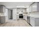 The kitchen features stainless appliances, wood grain flooring, and modern gray cabinetry at 1392 L Cooper Rd, Cameron, NC 28326