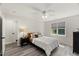 Serene bedroom showcasing wood-look floors, a ceiling fan, and a queen bed by a bright window at 1404 Kings Lassiter Way, Raleigh, NC 27614