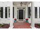 Charming home featuring a black front door, white brick, shutters, brick walkway, and potted plants at 1404 Kings Lassiter Way, Raleigh, NC 27614
