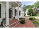 Welcoming front door with white pillars, black shutters, brick path, and manicured landscaping at 1404 Kings Lassiter Way, Raleigh, NC 27614