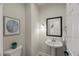 Clean half bath featuring a pedestal sink, toilet, and framed artwork at 1404 Kings Lassiter Way, Raleigh, NC 27614