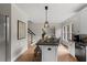 Stylish kitchen featuring a center island with seating, granite counters, and white cabinets at 1404 Kings Lassiter Way, Raleigh, NC 27614