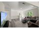 Sunlit living room boasts wood-look floors, a cozy couch, and a stylish black coffee table over a patterned rug at 1404 Kings Lassiter Way, Raleigh, NC 27614