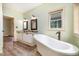 Bathroom featuring a standalone tub, dual sinks, granite counters, and white cabinets at 1408 Old Ivey Rd, Apex, NC 27523