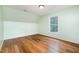 Bedroom featuring hardwood floors, light mint green paint, and a window at 1408 Old Ivey Rd, Apex, NC 27523