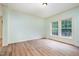 Bedroom with neutral walls, wood flooring, base molding, and two windows at 1408 Old Ivey Rd, Apex, NC 27523