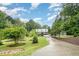 Beautifully landscaped front yard with mature trees and long driveway leading up to the house at 1408 Old Ivey Rd, Apex, NC 27523