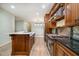 Kitchen features custom wood cabinets, stainless steel appliances and eat in island with quartz countertops at 1408 Old Ivey Rd, Apex, NC 27523
