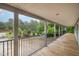 Extended covered porch with wood flooring, offering a relaxing view of the landscaped front yard and driveway at 1408 Old Ivey Rd, Apex, NC 27523