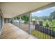 Inviting covered porch with wooden flooring and views of the surrounding greenery, a perfect outdoor retreat at 1408 Old Ivey Rd, Apex, NC 27523