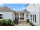 Rear exterior view with a covered patio and open patio with outdoor seating, and a manicured lawn at 1423 Tannin Dr, Durham, NC 27713