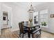 Dining room with dark wood table and upholstered bench seating gets natural light from the adjacent windows at 1423 Tannin Dr, Durham, NC 27713
