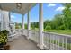 Covered porch with white columns, rocking chairs, and a view of the surrounding green space at 1423 Tannin Dr, Durham, NC 27713